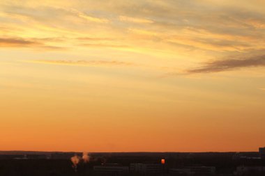 Ufkun altında güneş ve gün batımında veya şafakta güneşin aydınlattığı ateşli turuncu gökyüzünde bulutlar. Metin ve tasarım için yer.