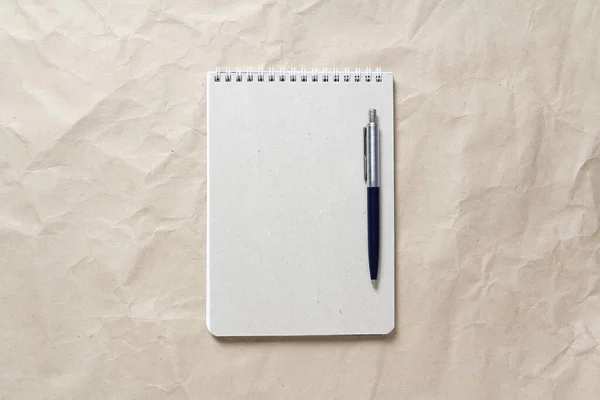 灰色记事本 白色卷曲的弹簧和笔背景米色折皱的工艺纸 有空白的文字和设计空间 — 图库照片