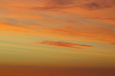 Ufkun altında güneş ve gün batımında veya şafakta güneşin aydınlattığı ateşli turuncu gökyüzünde bulutlar. Metin ve tasarım için yer.