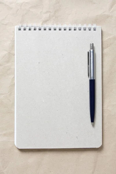 Сірий Блокнот Білою Скошеною Пружиною Ручкою Фоні Бежевого Збитого Ремісничого — стокове фото