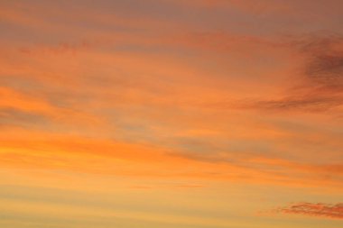 Ufkun altında güneş ve gün batımında veya şafakta güneşin aydınlattığı ateşli turuncu gökyüzünde bulutlar. Metin ve tasarım için yer.