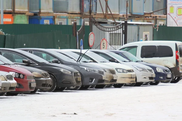 12.05.2020 Syktyvkar, Ρωσία, Ανοιχτός χώρος στάθμευσης αυτοκινήτων με μια σειρά αυτοκινήτων στο φόντο ενός χειμερινού αστικού περιβάλλοντος — Φωτογραφία Αρχείου