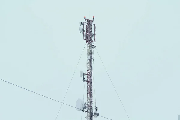 Basisstation mobiele netwerk antenne op een dak van een woongebouw tegen een grijze lucht. — Stockfoto