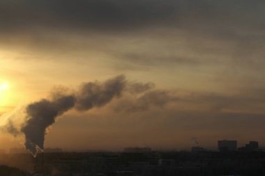 Güneş ufkun altında ve bulutlar alevli dramatik turuncu gökyüzünde gün batımında ya da şafakta güneş tarafından aydınlatılır.. 