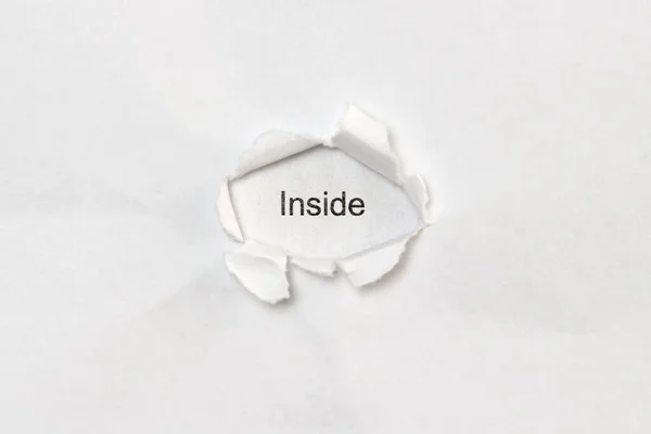 Word inside on white isolated background through the wound hole in the paper. — Foto de Stock