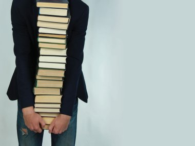 bir kitap yığını tutan adam