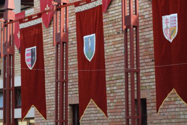 Çeşitli hanedan kalkanlarına sahip renkli pankartlar tuğla bir binaya asılarak bölgedeki sonbahar kutlamalarının şenlikli atmosferini artırıyor..