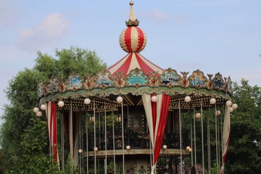 Kaliteli atlıkarınca, güneşli bir günde huzurlu bir parkta yemyeşil bir alanla çevrili canlı tasarımlar ve karmaşık ayrıntılar içeriyor. Neşeli anıları davet ediyor..