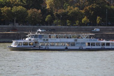 Bir tur teknesi, güneşli bir günde yolculara rahatlatıcı bir deneyim sunarak nehir boyunca seyahat eder. Şehir manzarası yolculuk için pitoresk bir zemin sağlar..