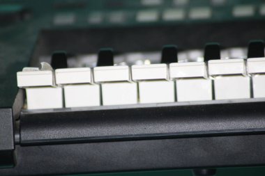 Görüntü, eskimiş tuşlara ve karmaşık mekanizmalara odaklanarak bir müzik stüdyosundaki yaşını ve karakterini vurgulayan klasik bir klavyenin yakın çekimini yakalıyor..