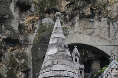 Geleneksel tasarımlarla süslenmiş karmaşık taş yapılar, yıpranmış uçurumların bir zeminine karşı duruyor, mimari güzellik ve kültürel önemi gözler önüne seriyor..