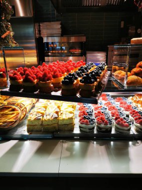 Canlı bir tatlı dizisi yabanmersini, ahududu ve krema dolu ikramlar sergiliyor, fırın ortamında düzgünce düzenleniyor, müşterileri hoşgörüye davet ediyor..