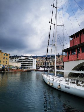 Palmiye ağaçları ve çizgili tentelerin bulunduğu canlı bir kafe, ziyaretçileri hareketli bir alışveriş meydanında ağırlayarak bulutlu gökyüzüne rağmen rahat bir atmosfer yaratıyor..