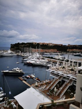 Bulutlu bir öğleden sonra Monako 'daki marinada sayısız zarif yat kuyruğu oluştu. Hareketli liman, arka planda çarpıcı binalar bulunan bölgenin lüks yaşam tarzını yansıtıyor..