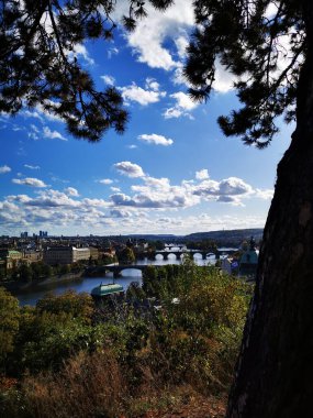 Vltava Nehri verimli bir noktadan Prag 'a doğru esiyor. Kıyılarında muhteşem tarihi binalar var. Bulutlarla dolu mavi bir gökyüzüne karşı dizilmiş..