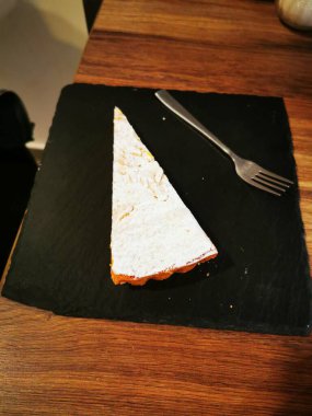 Palmiye ağaçları ve çizgili tentelerin bulunduğu canlı bir kafe, ziyaretçileri hareketli bir alışveriş meydanında ağırlayarak bulutlu gökyüzüne rağmen rahat bir atmosfer yaratıyor..