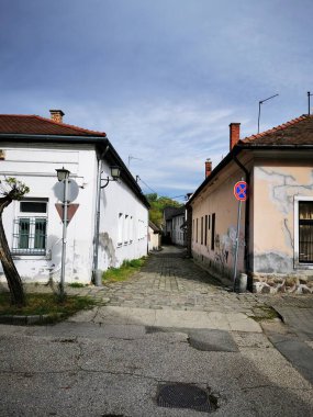 Parke yolu, açık mavi gökyüzünün altında farklı cephelere sahip iki tarihi bina arasında gidip geliyor. Kasabanın cazibesinin keşfine davetiye çıkarıyor..