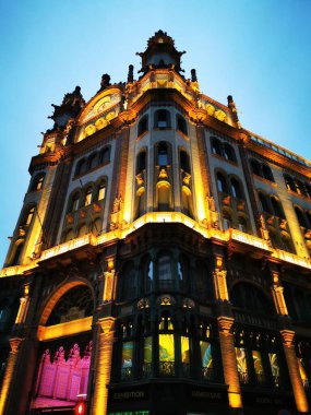 Görkemli tarihi yapı akşam gökyüzüne karşı güzelce aydınlatılırken, önünde belirgin bir binicilik heykeli duruyor ve zengin tarihin özünü yansıtıyor.. 