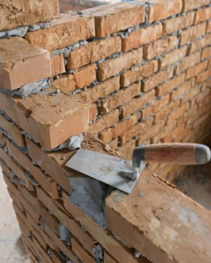 Tuğla tuğla, belli bir şekilde katlanmış ve harçla sabitlenmiş. Dış duvarların inşasında çimentoya tuğla koymak, endüstri ayrıntıları