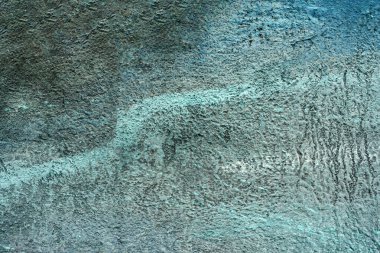 Duvarda desenli bir alçı parçası var. Soyut sanat, arka plan. Sert boya darbeleri. Fırça darbelerine yakın çekim. Yüksek kaliteli desenli detaylar.