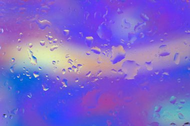 Gökkuşağının tüm renklerine sahip çok renkli bir arkaplanda su damlaları olan soyut arkaplan