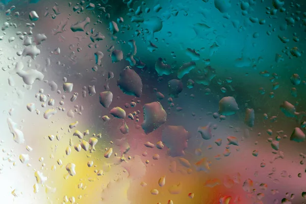 Gökkuşağının tüm renklerine sahip çok renkli bir arkaplanda su damlaları olan soyut arkaplan