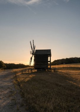 Geleneksel bir köy değirmeni bir tarlada duruyor.