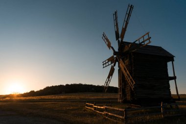 Geleneksel bir köy değirmeni bir tarlada duruyor.