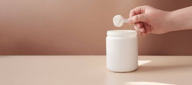 El ele tutuşan balık kolajeni. Konteynır veya kavanozdaki kolajen peptidler. İçeceği karıştırmak için toz. Sağlık hizmetleri destek konsepti. Deri ve eklemler için kolajen. Boşluğu kopyala
