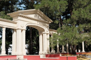 Orman parkında antik tarzda güzel bir kemer. Sokak gösterisi ya da sunumlar için bir sahnenin parçası. Sütunlar, sütunlar ve liflerle dolu İrem şehrinde..