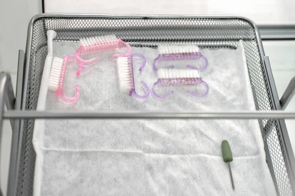 professional nail salon brushes disinfection. clean brushes and nail file on medical tray after cleaning in autoclave device. sterilization of instruments in beauty salon. tools and accessories.