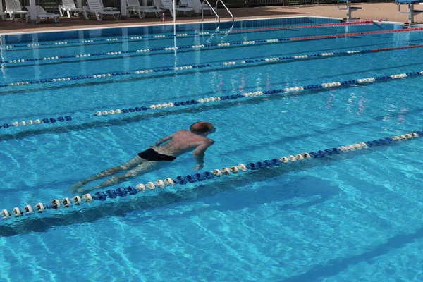 중년의 남자가 수영장에서 수영과 다이빙을 있습니다 사람의 뒷모습 중년의 스포츠와 — 스톡 사진