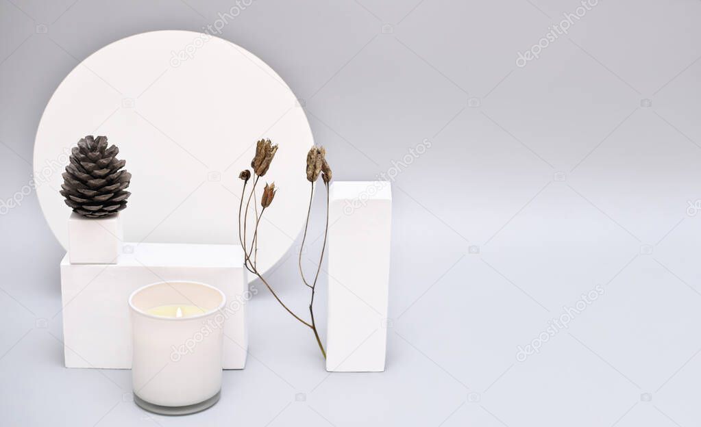 Abstract background mock up with white podium for product display. Blank product stand in minimal slyle on grey background. pine cone and white soy candle with dry branch.