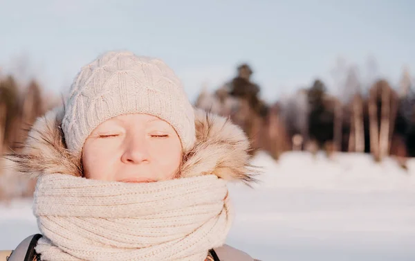 middle age woman relaxing under winter sun.