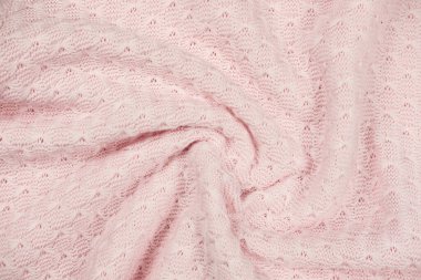 pink knitted fabric swirl. twisted soft sweater textured background. pink female textile. winter outfit cozy pullover.