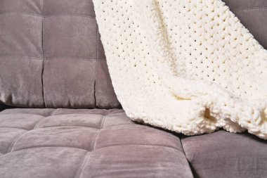 Modern bir kanepede rahat bir ekose ya da örgü battaniye. Konforlu ev konsepti. Dinlenmek ve stres atmak için sakin ve sakin bir yer. zihin dengesi ve iç huzur