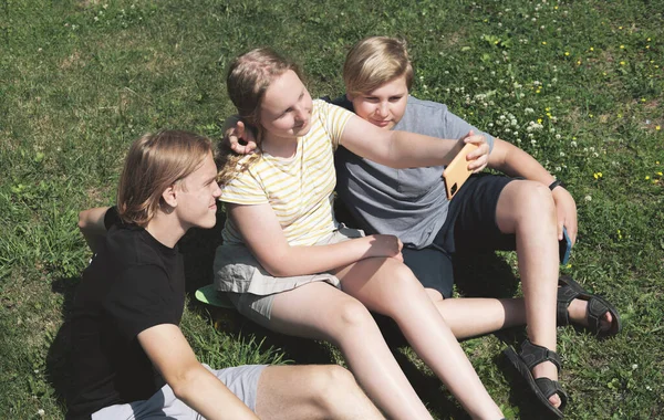 Tres Adolescentes Haciendo Selfie Sentado Una Hierba Chica Adolescente Sosteniendo — Foto de Stock