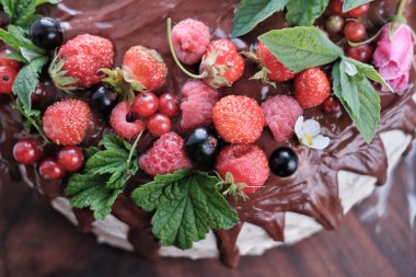 Düğün pastası böğürtlen dekoru yakın plan. Çikolata soslu ve yoğurtlu çilek, ahududu ve nane yapraklı..