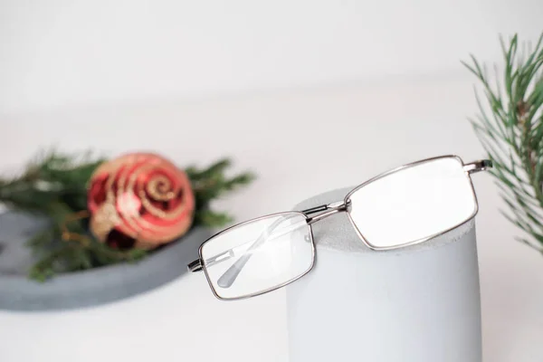 Brille auf einem grauen geometrischen Podium. Weihnachtsdekoration. Sehvermögen, Sehvermögen. Optikgeschäft Winterschlussverkauf — Stockfoto