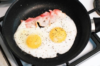 Fırında pişmiş yumurta ve domuz pastırmalı geleneksel İngiliz kahvaltısı. Hafta sonu ev kahvaltısı zamanı.