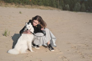 Genç bir kadın köpeğine sarılıyor ve kumlu bir nehir kıyısında otururken onunla konuşuyor. Sonbahar, evcil hayvanlarla vakit geçiriyor. Sevgi ve şefkat, dostluk ve birliktelik