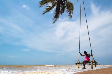 Asılı bir sandalyede oturan Afrikalı kadın. Axim Gana Batı Afrika Plajı 2018 Kasım