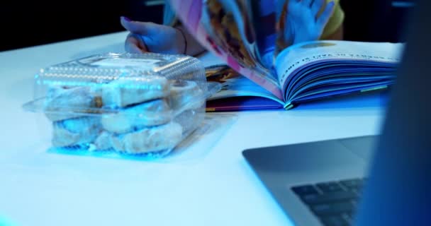 Cakes, dessert on the table in the kitchen. A girl browses the magazine — Video Stock