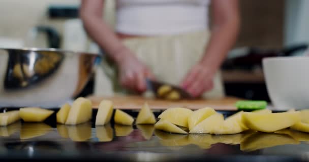 Raw potatoes, cut on a baking tray on the kitchen table. Slow motion. — Stockvideo