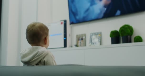 Dítě se dívá na televizi a hledá kreslené filmy. — Stock video