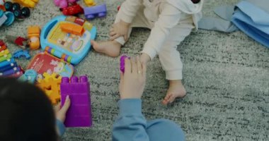 Sevimli küçük çocuk, evde annesiyle oyuncaklarla oynuyor.