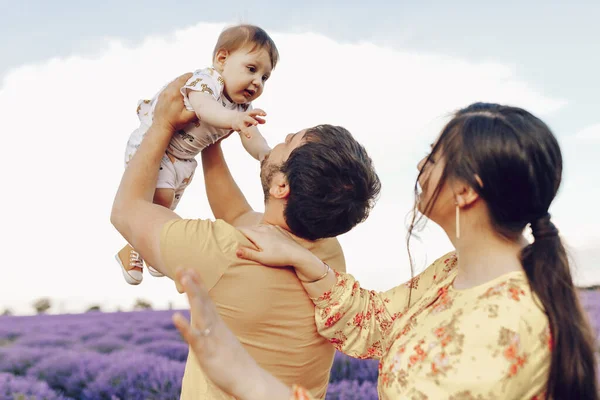 Anne ve baba, küçük oğullarıyla lavanta tarlasında oynuyorlar. Yaz günü.