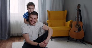 Evde küçük bir çocuk ve genç bir babanın portresi. Mutlu çocuk.