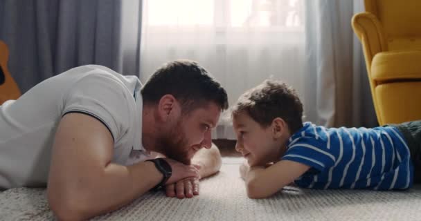 Otec si hraje s dítětem, synku, doma v obýváku. Šťastné dítě. — Stock video