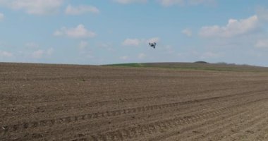 İnsansız hava aracı tarla üzerinde uçuyor, toprağın kalitesini kontrol ediyor..